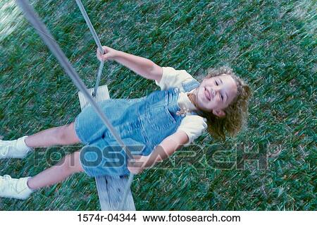 High angle view of a girl sitting on a swing View Large Photo Image Picture - High angle view of a girl sitting on a swing. Fotosearch