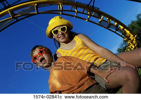 Stock Image - Low angle view of a boy and a girl in an amusement park. Fotosearch