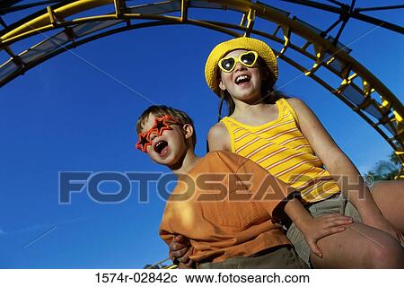 Low angle view of a boy and a girl in an amusement park View Large Photo Image Stock Image - Low angle view of a boy and a girl in an amusement park. Fotosearch