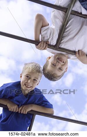Low angle view of two boys playing on monkey bars View Large Photo Image Stock Image - Low angle view of two boys playing on monkey bars. Fotosearch