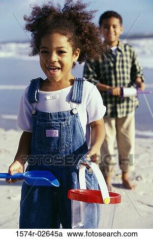 Portrait of a boy and a girl playing on the beach View Large Photo Image Stock Image - Portrait of a boy and a girl playing on the beach. Fotosearch