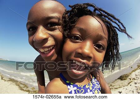 Portrait of a boy and a girl playing on the beach View Large Photo Image Stock Image - Portrait of a boy and a girl playing on the beach. Fotosearch