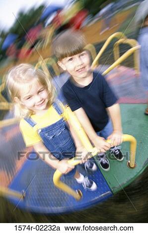 Portrait of a boy and a girl standing on a merry-go-round View Large Photo Image Stock Image - Portrait of a boy and a girl standing on a merry-go-round. Fotosearch