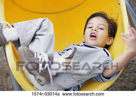 Portrait of a boy lying on a slide View Large Photo Image Stock Image - Portrait of a boy lying on a slide. Fotosearch