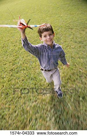Portrait of a boy running with a toy airplane View Large Photo Image Stock Image - Portrait of a boy running with a toy airplane. Fotosearch