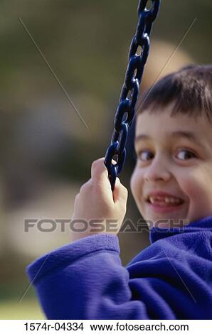 Portrait of a boy sitting on a swing View Large Photo Image Picture - Portrait of a boy sitting on a swing. Fotosearch