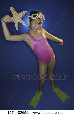 Portrait of a girl in swimsuit holding a starfish View Large Photo Image Stock Image - Portrait of a girl in swimsuit holding a starfish. Fotosearch