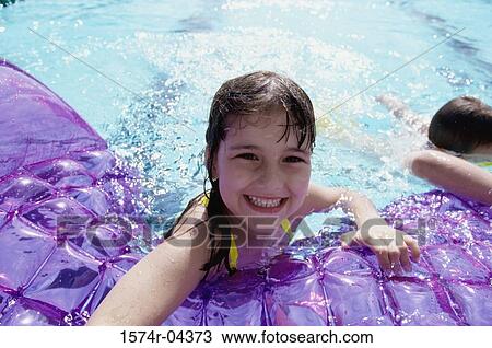 Stock Image - Portrait of a girl playing in a swimming pool. Fotosearch