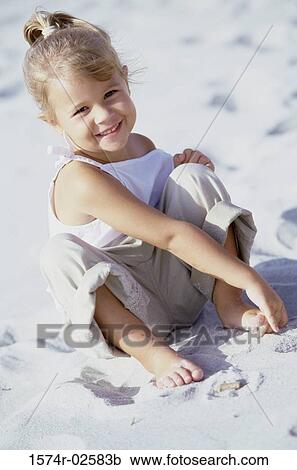 Portrait of a girl playing in the sand on the beach View Large Photo Image Stock Image - Portrait of a girl playing in the sand on the beach. Fotosearch