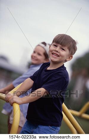 Portrait of two boys standing on a merry-go-round View Large Photo Image Stock Image - Portrait of two boys standing on a merry-go-round. Fotosearch