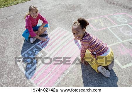 Portrait of two girls drawing on the ground with chalk View Large Photo Image Stock Image - Portrait of two girls drawing on the ground with chalk. Fotosearch