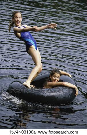 Portrait of two girls playing in water with inner tube View Large Photo Image Stock Image - Portrait of two girls playing in water with inner tube. Fotosearch