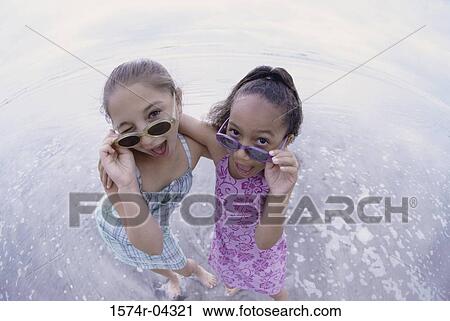 Portrait of two girls standing on the beach View Large Photo Image Stock Image - Portrait of two girls standing on the beach. Fotosearch