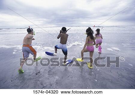 Rear view of two boys and two girls wearing snorkels and flippers walking on the beach View Large Photo Image Stock Image - Rear view of two boys and two girls wearing snorkels and flippers walking on the beach. Fotosearch