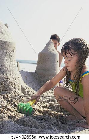Side profile of a girl and a boy making sand castles on the beach View Large Photo Image Stock Image - Side profile of a girl and a boy making sand castles on the beach. Fotosearch