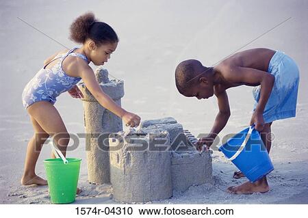Side profile of a girl and a boy making sand castles on the beach View Large Photo Image Stock Image - Side profile of a girl and a boy making sand castles on the beach. Fotosearch