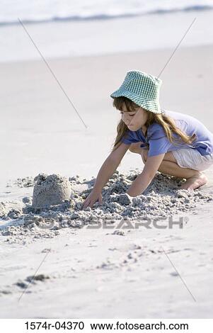 Side profile of a girl playing with sand on the beach View Large Photo Image Stock Image - Side profile of a girl playing with sand on the beach. Fotosearch