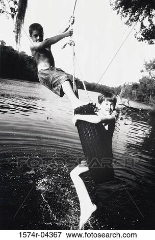 Side profile of two boys on a tire swing View Large Photo Image Stock Photo - Side profile of two boys on a tire swing. Fotosearch