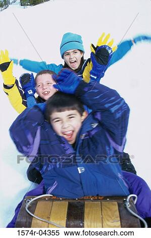 Two boys and a girl riding a sled View Large Photo Image Stock Photography - Two boys and a girl riding a sled. Fotosearch