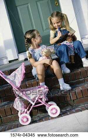 Two girls sitting together with their dolls View Large Photo Image Stock Photography - Two girls sitting together with their dolls. Fotosearch