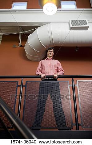 Stock Image - Low angle view of a businessman against a railing. Fotosearch