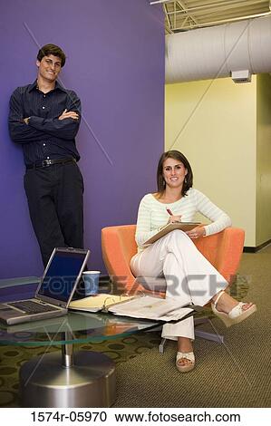 Stock Image - Portrait of a businessman and a businesswoman smiling. Fotosearch