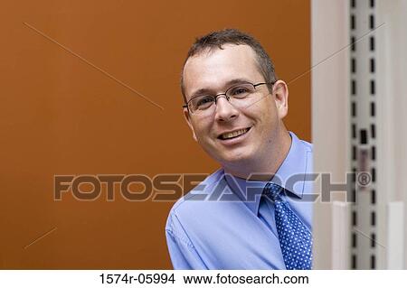Portrait of a businessman peeking from behind a wall View Large Photo Image Picture - Portrait of a businessman peeking from behind a wall. Fotosearch