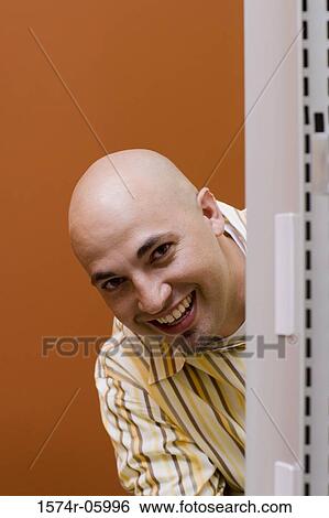 Portrait of a businessman peeking from behind a wall View Large Photo Image Stock Photograph - Portrait of a businessman peeking from behind a wall. Fotosearch