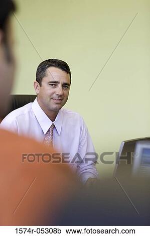 Portrait of a businessman sitting in an office View Large Photo Image Stock Image - Portrait of a businessman sitting in an office. Fotosearch