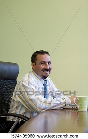 Portrait of a businessman sitting in an office View Large Photo Image Stock Image - Portrait of a businessman sitting in an office. Fotosearch