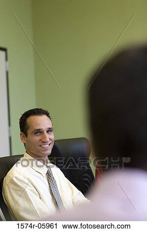 Portrait of a businessman sitting in an office View Large Photo Image Stock Image - Portrait of a businessman sitting in an office. Fotosearch