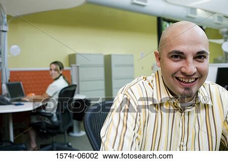Stock Image - Portrait of a businessman sitting in an office. Fotosearch