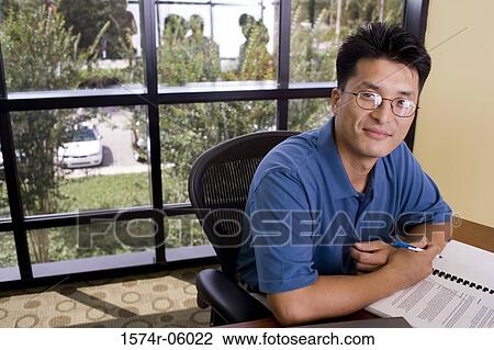 Portrait of a businessman sitting in an office View Large Photo Image Stock Image - Portrait of a businessman sitting in an office. Fotosearch