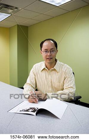 Portrait of a businessman sitting in an office View Large Photo Image Stock Image - Portrait of a businessman sitting in an office. Fotosearch