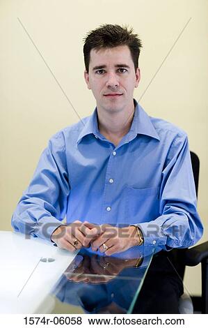 Portrait of a businessman sitting in an office View Large Photo Image Stock Photo - Portrait of a businessman sitting in an office. Fotosearch