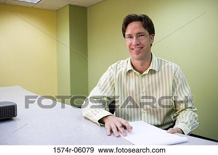 Portrait of a businessman sitting in an office View Large Photo Image Stock Photo - Portrait of a businessman sitting in an office. Fotosearch