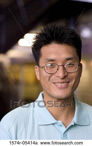 Stock Image - Portrait of a businessman smiling in an office. Fotosearch