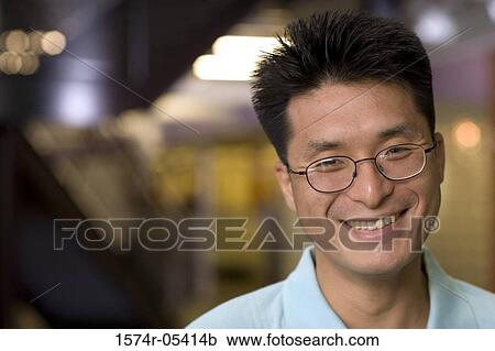 Portrait of a businessman smiling in an office View Large Photo Image Stock Image - Portrait of a businessman smiling in an office. Fotosearch