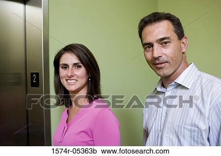 Portrait of a businesswoman and a businessman standing near an elevator View Large Photo Image Stock Image - Portrait of a businesswoman and a businessman standing near an elevator. Fotosearch