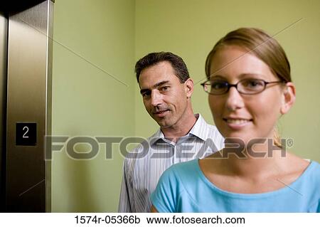 Portrait of a businesswoman and a businessman standing near an elevator View Large Photo Image Stock Image - Portrait of a businesswoman and a businessman standing near an elevator. Fotosearch