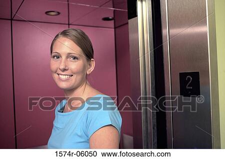 Stock Image - Portrait of a businesswoman standing near an elevator. Fotosearch