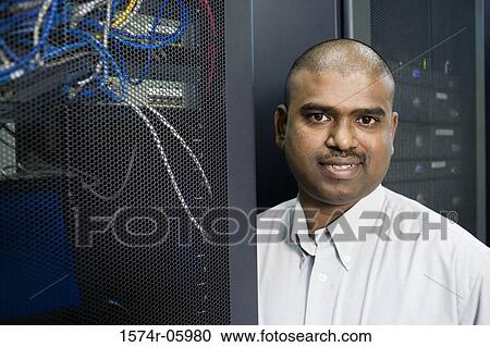 Stock Image - Portrait of a technician standing in a server room. Fotosearch
