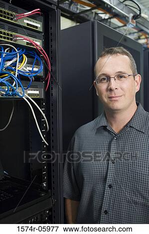 Stock Photo - Portrait of a technician standing in a server room. Fotosearch