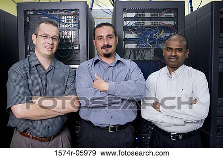 Stock Photo - Portrait of three technicians standing in a server room. Fotosearch