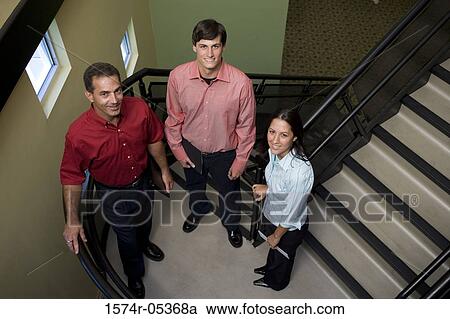 Portrait of two businessmen and a businesswoman standing on stairs View Large Photo Image Stock Image - Portrait of two businessmen and a businesswoman standing on stairs. Fotosearch