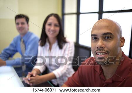 Portrait of two businessmen and a businesswoman sitting in a conference room View Large Photo Image Stock Image - Portrait of two businessmen and a businesswoman sitting in a conference room. Fotosearch
