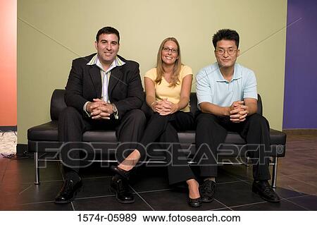 Portrait of two businessmen and a businesswoman sitting on a couch View Large Photo Image Stock Photo - Portrait of two businessmen and a businesswoman sitting on a couch. Fotosearch