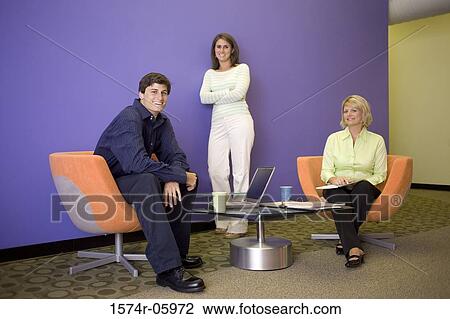 Stock Image - Portrait of two businesswomen and a businessman smiling. Fotosearch