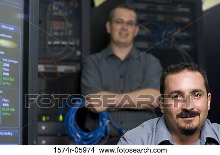 Picture - Portrait of two technicians in a server room. Fotosearch