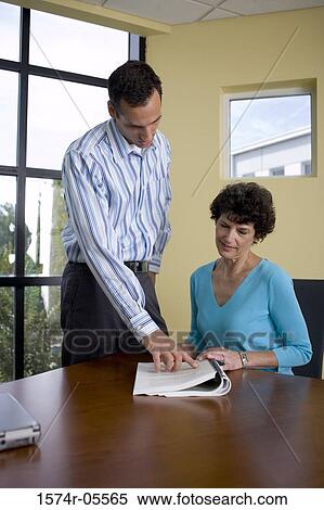 Stock Photography - Businessman and a businesswoman reading documents. Fotosearch